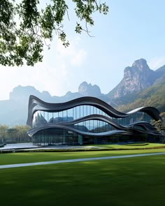 the building is shaped like a wave on top of it's roof, with mountains in the background