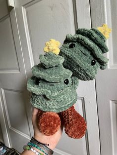 a person holding two stuffed animals in front of a door