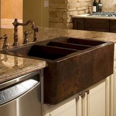 a kitchen sink sitting under a faucet next to a stove and counter top