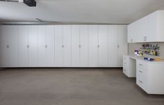 an empty room with white cabinets and drawers