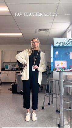 a woman standing in front of a sign that says fav teacher oots on it