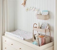 a baby's crib in a white room with teddy bears and other items