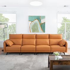 a living room with a couch, coffee table and large windows