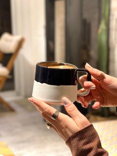 two hands holding coffee cups in front of each other