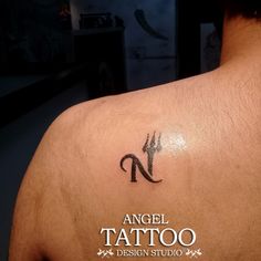 a tattoo on the back of a man's upper arm, with an n