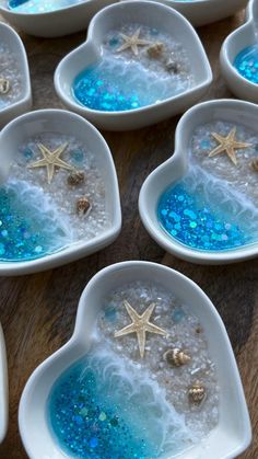 several heart shaped dishes filled with blue liquid and starfish