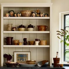 a kitchen shelf filled with lots of dishes and vases on top of each other