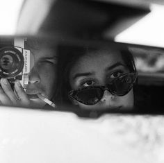 a woman taking a selfie in the rear view mirror