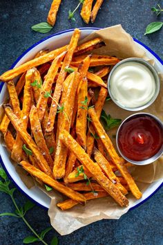 baked sweet potato fries with ketchup and ranch dressing on a blue plate, ready to be eaten