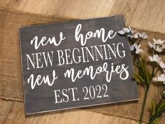 a wooden sign that says new home, new beginnings and memories est 2022 on it