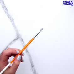 someone is drawing on the wall with colored pencils