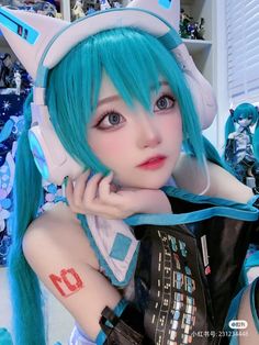 a close up of a person with blue hair wearing headphones and holding a cell phone