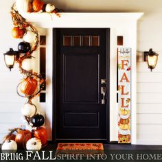 a black front door decorated with pumpkins and decorations