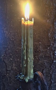 a lit candle sitting on top of a rock