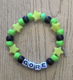 a green and black beaded bracelet that says goree with yellow stars on it