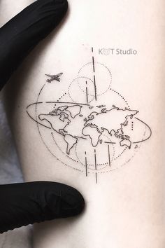 a woman's thigh with a world map tattoo on her left side ribcage