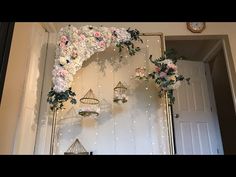 a wall decorated with flowers and birdcages for a wedding or baby's first birthday