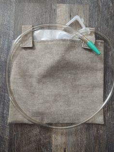 a round bag with a green handle on top of a wooden table