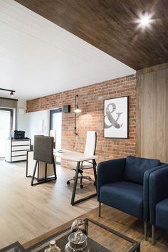 a living room filled with furniture next to a brick wall and wooden floored walls