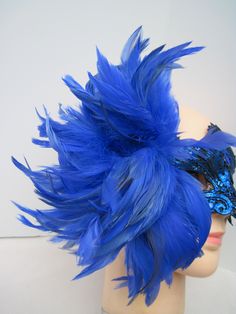 * Designed on a sturdy acrylic shiny half mask accented around the eyes with black liner and royal blue shiny embroidered flower and scrolled patterned lace in a custom design. * The right side is adorned with puffy plumes of fluffy and royal blue feathers. * To secure the mask there are two satin black ribbons on each side to be tied in the back. * A great piece for a Masked Ball, Class Reunion, Costume party or Play, Carnivale, Mardi Gras, Burlesque Occasion, Masquerade Ball, or Venetian Celeb Blue Masks And Prosthetics For Carnival Costume Party, Blue Masks And Prosthetics For Carnival Party, Blue Masks For Carnival Costume Party, Blue Masquerade Mask For Mardi Gras Costume Party, Blue Eye Mask For Party, Blue Masquerade Mask For Carnival Costume Party, Elegant Blue Mask For Masquerade, Blue Venetian Masks For Carnival, Blue Venetian Masquerade Mask For Party