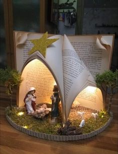 the nativity scene is made out of an open book and lit up with lights