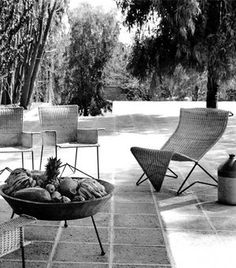 black and white photograph of outdoor furniture with pineapples in the bowl on patio