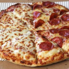 a pepperoni pizza sitting on top of a cardboard box