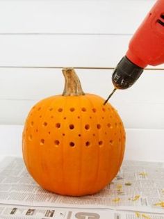 a drill is being used to paint a pumpkin with holes in the center and bottom