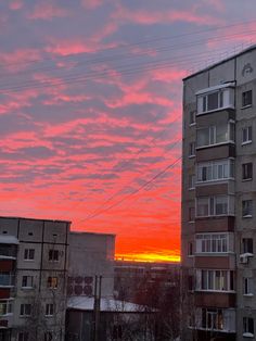 the sun is setting over an apartment building