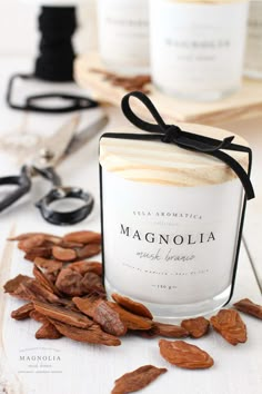 a glass jar filled with almonds next to scissors and other items on a table