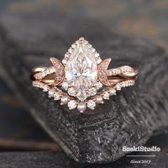 an engagement ring with a pear shaped diamond surrounded by small white and pink diamonds on top