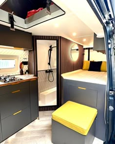 the interior of a camper with yellow and gray accents, including a kitchen area