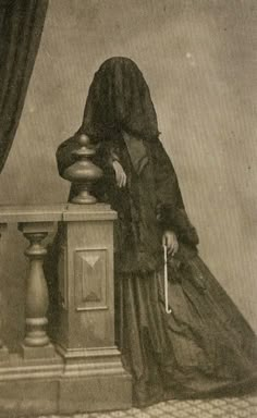 an old fashion photo of a woman standing next to a clock