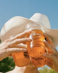 a woman wearing a cowboy hat drinking from a beer glass with the word cherry on it