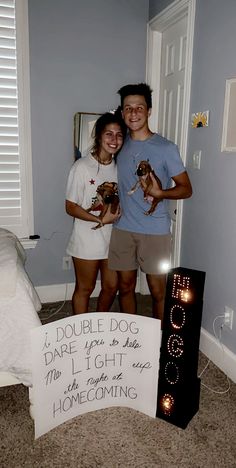 two people standing next to each other in a room with a sign on the floor