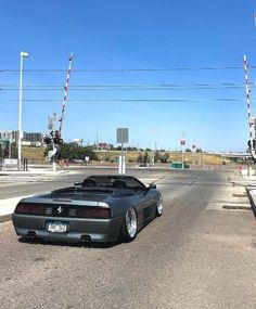 a black sports car is parked on the side of the road in front of an intersection