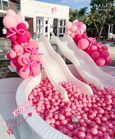 pink and white balloons are floating in a large bowl with water inside, on display at a wedding reception