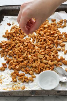 a person scooping nuts onto a baking sheet