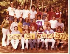 a group of people holding up signs in front of some trees and bushes with the words camp chi palm 1971 written on them