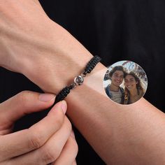 a woman is holding onto a bracelet with a photo on the front and back of it