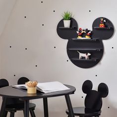 a mickey mouse head on the wall next to a table with two chairs and a desk