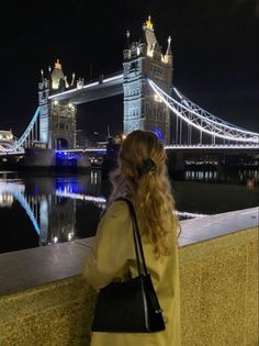 a woman is looking at the tower bridge