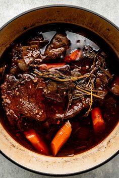 a pot filled with stew and carrots on top of a table