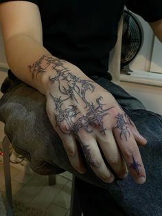 a person with tattoos on their hands sitting down