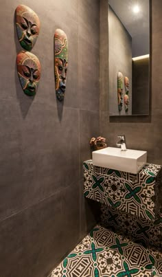 a bathroom with two masks on the wall