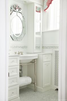 a bathroom with a sink, mirror and towel rack