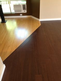 an empty room with hard wood flooring and air conditioner in the window sill