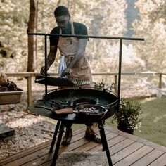 a man grilling food on an outdoor bbq