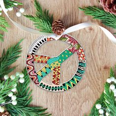 a christmas ornament on a wooden table with pine cones