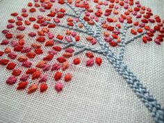 a close up of a cross stitch pattern with a tree on it's side